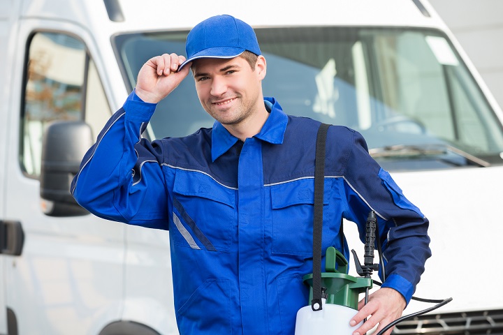 happy pest control company owner in blue uniform